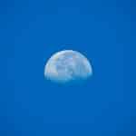 La lune en plein jour dans un ciel bleu